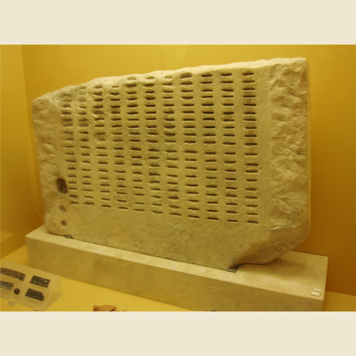 Kleroterion de piedra con filas de ranuras en el Museo del Ágora Antigua de Atenas